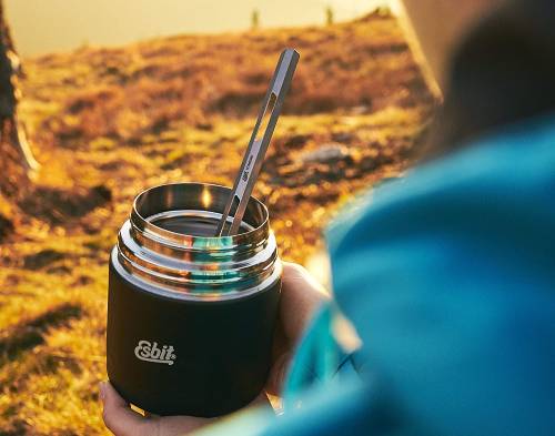 a woman holding a soup thermos