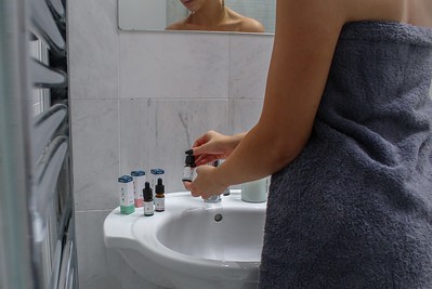 A woman in the bathroom taking a supplement