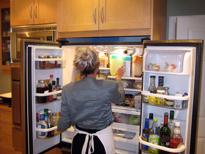 a woman taking juice from the refrigerator