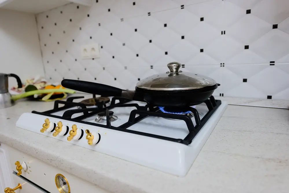 a-white-kitchen-counter-with-a-pan-and-stovetop-on-it