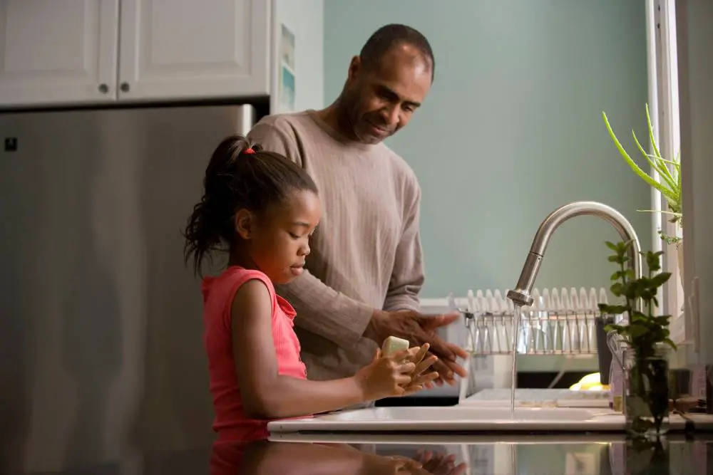 a father and her daughter washing their hands