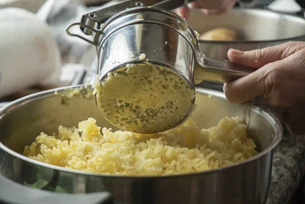 The process of making puree with stainless steel potato ricer
