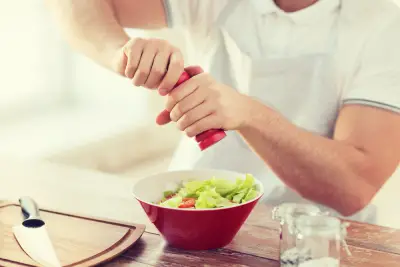 adding a seasoning to a salad