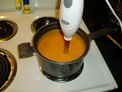 blending the hot soup in the pan