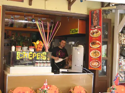 A man using wired kitchen tool to make thin slices of lamb