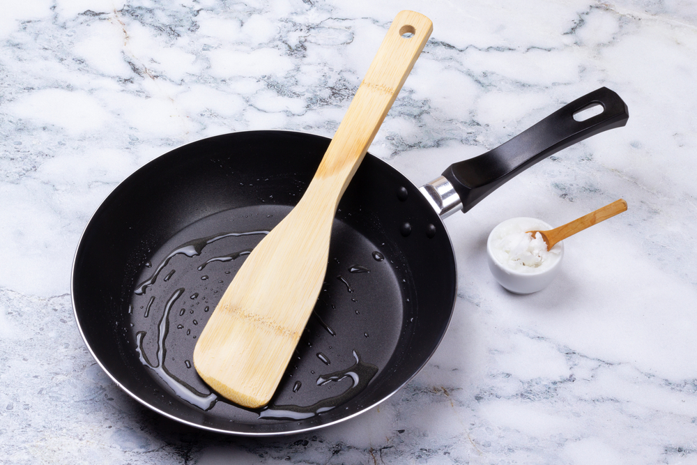 Coconot oil with a spatula in a cast iron pan