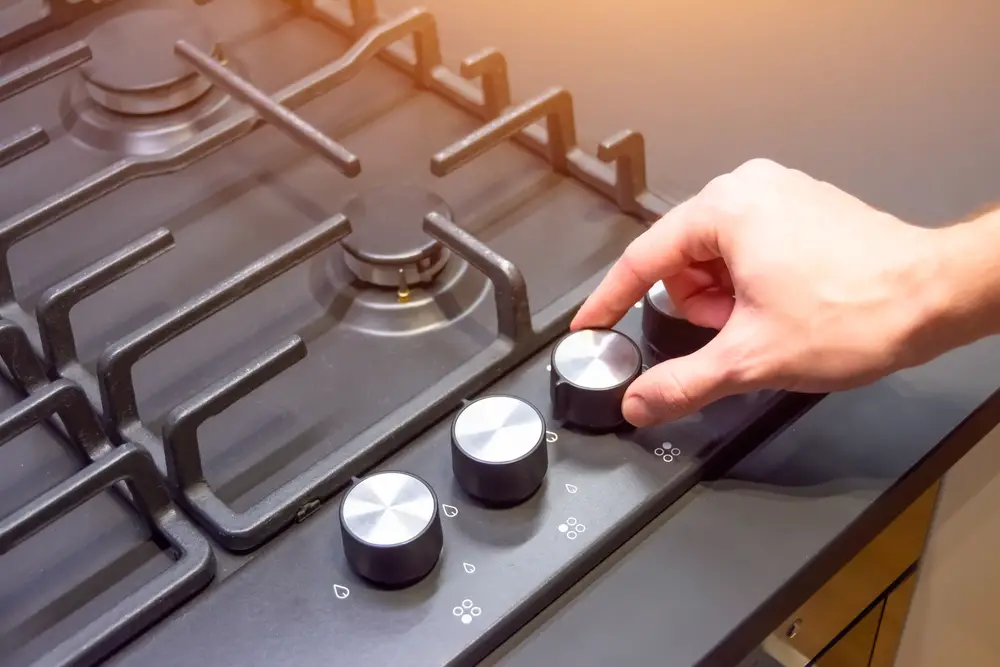 hand turning stove's control knob